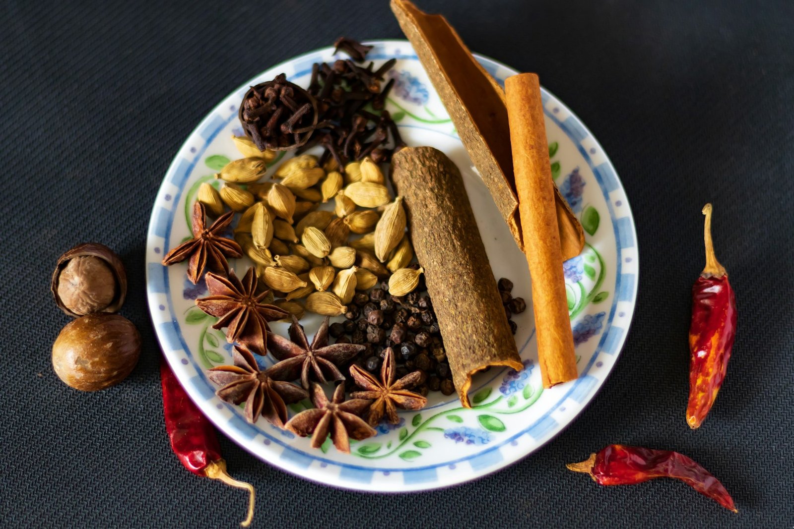 Whole and ground Indian spices arranged on a plate