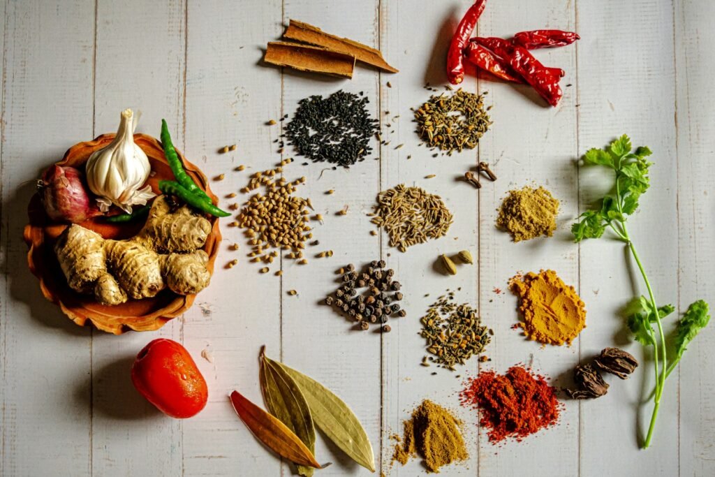 A variety of Indian spices arranged in bowls on a white table